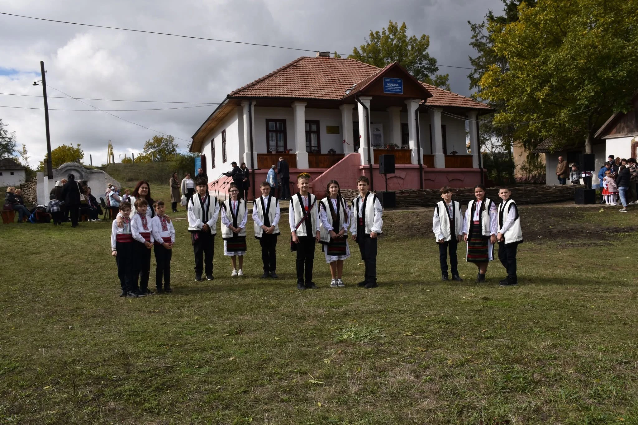 Elevi în costume populare în fața muzeului la inaugurare